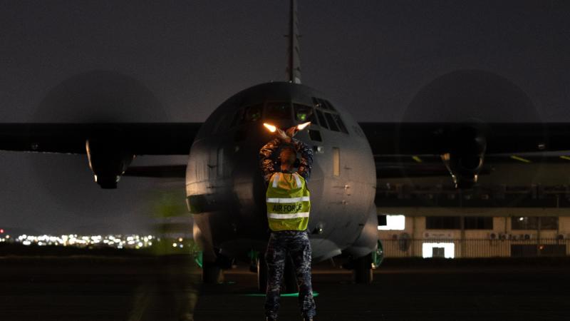 Royal Australian Air Force Aircraftman Sam Schmidt, from the No. 382 Squadron, marshals a C-130J from RAAF Base Richmond at the Air Movements Wing – Port Moresby, Papua New Guinea. Photo: Corporal Jonathan Goedhart