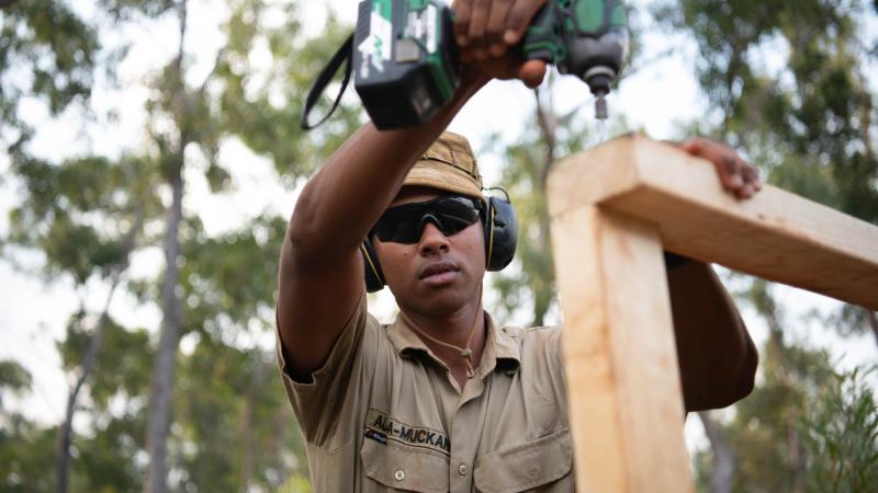 Australian Army soldier Sapper Jeirome Auda-Muckan from the 6th Engineer Support Regiment uses spare materials to enhance the living quarters of AACAP 2022 contingent members living at Camp Birt near Gapuwiyak, on June 22. Photo: Corporal Lucas Petersen