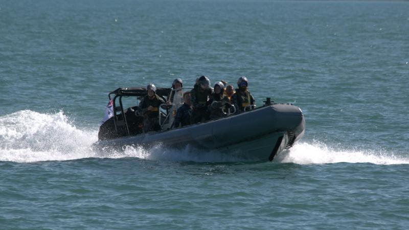 Personnel from HMAS Maryborough transport three rescued civilians in a rigid hull inflatable boat off Darwin, Northern Territory.