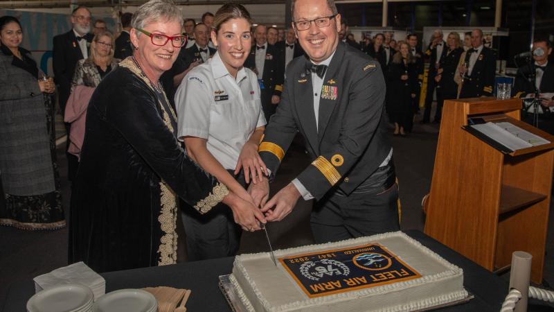 Mayor of the City of Shoalhaven Amanda Findley, left, Maritime Logistics Personnel Leading Seaman Stephanie Hart and Commander Fleet Air Arm Commodore David Frost, cut a cake to celebrate the 75th anniversary of the FAA. Photo: Leading Seaman Ryan Tascas