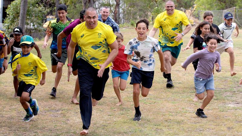 Indigenous Advisory Committee members Patrick Johnson, left, and Kyle Vander-Kuyp are joined by Air Mobility Group Warrant Officer Stephen Weaver, centre, in a race with local kids on Thursday Island. Photo: Leading Aircraftwoman Kate Czerny