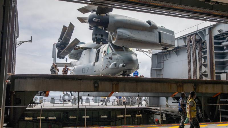 The aviation support team from HMAS Canberra transfer an embarked US Marine Corps MV-22B Osprey into the ship’s hanger. Photo: Petty Officer Christopher Szumlanski