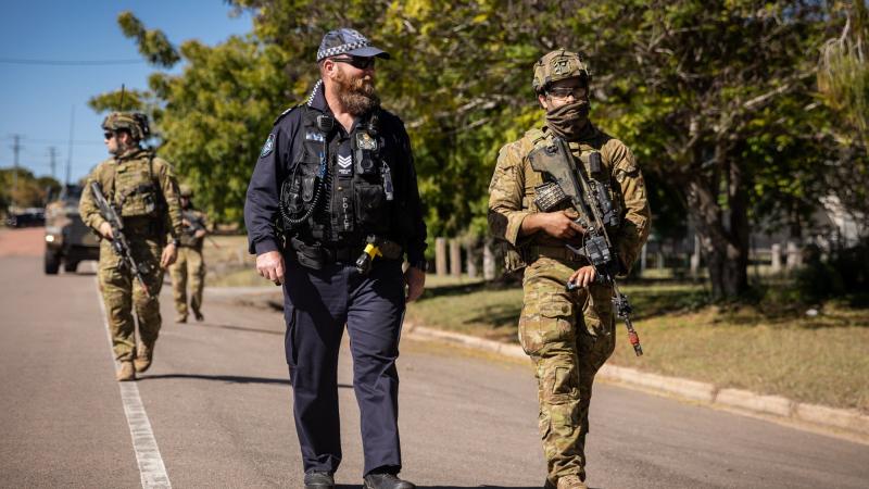 Soldiers from the 3rd Battalion, Royal Australian Regiment, and Queensland Police Service Officer Tony Hoise patrol through Charters Towers in Queensland, during Exercise Brolga Run 2022. Photo: Gunner Gregory Scott