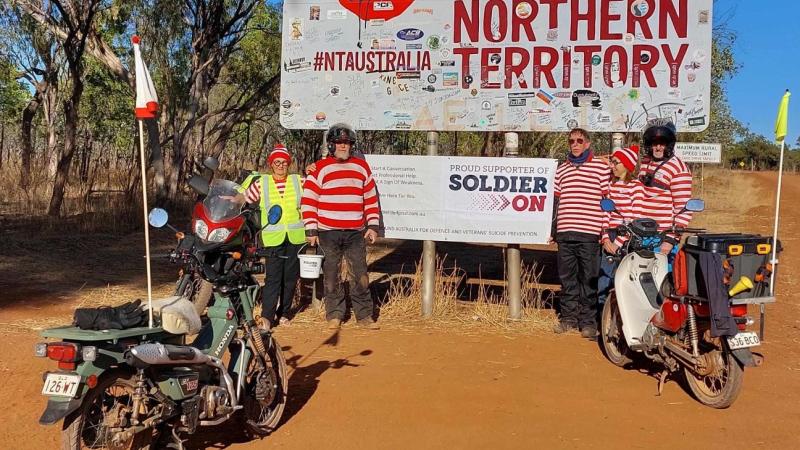 Dr Michael Davey, right, and his team stop for a photo at the Northern Territory border as they ride around Australia raising money for Soldier On. Photo: Sergeant Sebastian Beurich