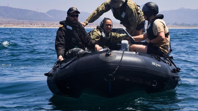 Multinational training participants prepare to launch a REMUS 100 autonomous underwater vehicle (AUV) as a part of an AUV and unmanned underwater vehicles search and calibration training event conducted during RIMPAC 2022. Photo: Seaman Victoria Danser