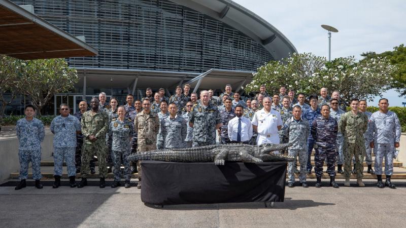 Exercise Kakadu Final Planning Conference delegates gather outside Darwin Convention Centre accompanied by the adopted exercise mascot, a 4-metre-long wooden crocodile nicknamed 'Fluffy'. Photo: Sergeant Pete Gammie
