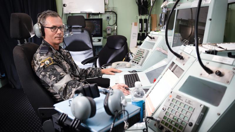 Flight Lieutenant Allister Daish mans the air traffic control console in the air traffic control room on board HMAS Canberra during Exercise Rim of the Pacific (RIMPAC) 2022. Photo: Leading Seaman Matthew Lyall
