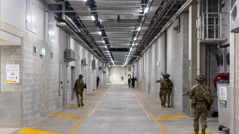Members of the ADF and Queensland Police Service clear the lower levels of the Queensland Country Bank Stadium as part of Exercise Austral Shield 2022 in Townsville. Photo: Corporal Jonathan Goedhart