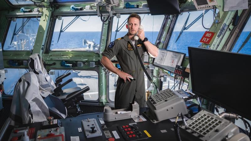 Lieutenant Samuel Laidlaw controls air traffic from the flight bridge on board HMAS Canberra during Exercise Rim of the Pacific (RIMPAC) 2022. Photo: Leading Seaman Matthew Lyall