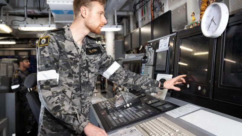 Leading Seaman Marine Technician Blake Fulton uses a marine engineering console in the central control station of HMAS Canberra. Photo: Leading Seaman Matthew Lyall