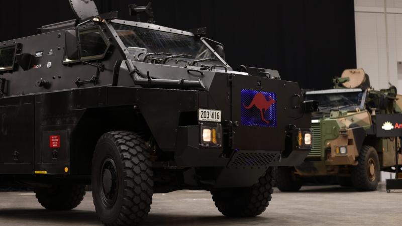 A Bushmaster Electric Protected Mobility Vehicle after being unveiled during the Chief of Army Symposium 2022. In the background is a Bushmaster Protected Mobility Vehicle fitted with ruggedized solar panels. Photo: Warrant Officer Class Two Max Bree