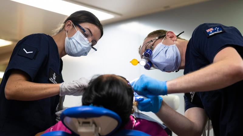 Dentist Flight Lieutenant Jack O'Neill, right, and Dental Assistant Leading Aircraftwoman Ocean Mitchell perform a dental procedure on board United States Hospital Ship USNS Mercy during Pacific Partnership. Photo: Corporal Brandon Grey