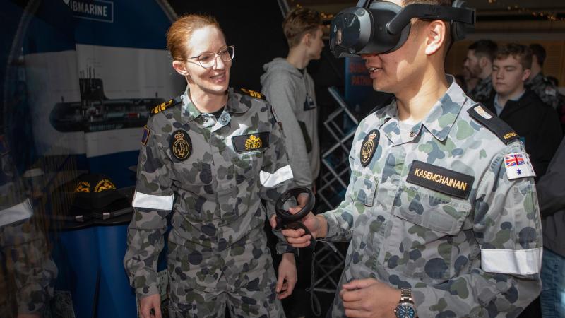 Lieutenant Commander Siobhan Sturdy guides Midshipman Kane Kasemchainan through a virtual training demonstrator at the Australian Defence Force Academy open day. Photos: Petty Officer Bradley Darvill