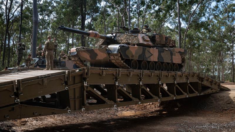 Lance Corporal Jesse McMah, from 2nd/14th Light Horse Regiment (Queensland Mounted Infantry) guides an M1A1 Abrams main battle tank over a medium girder bridge during training at Gallipoli Barracks, Brisbane. Photo: Corporal Nicole Dorrett