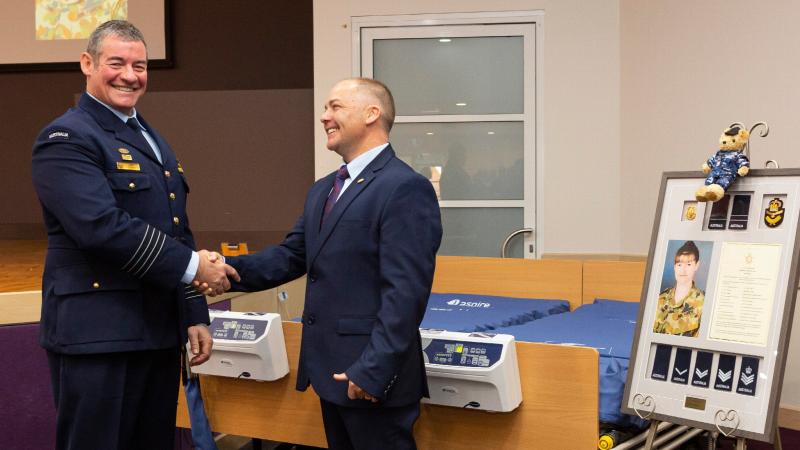 Senior ADF Officer at RAAF Base Amberley Group Captain Iain Carty and Bruce McGowan stand in front of the two cuddle beds presented to the palliative care unit of Warwick Hospital. Photo: Leading Aircraftman Stewart Gould