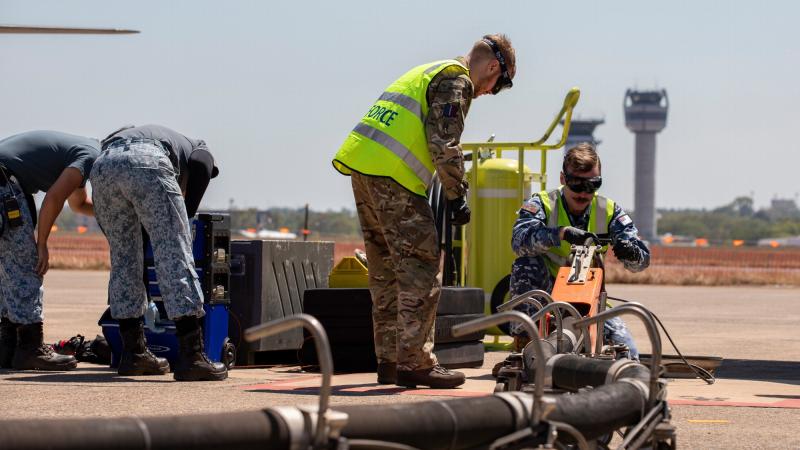 RAAF Leading Aircraftman Thomas Clarke-Kelly, right, and UK Royal Air Force Air Specialist Class One Declan McTrusty, centre, work together to refuel a Republic of Singapore Air Force F-15SG Eagle aircraft. Photo: Leading Aircraftman Chris Tsakisiris