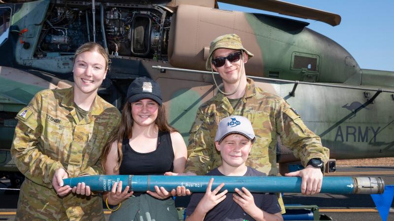 Craftsman Amber Toner, left, and Craftsman Cameron Powell, from 1st Aviation Regiment, with Emily and Oliver Taaffe and a 70mm rocket from the Tiger helicopter during the Exercise Pitch Black open day at RAAF Base Darwin. Photo: Corporal Kylie Gibson