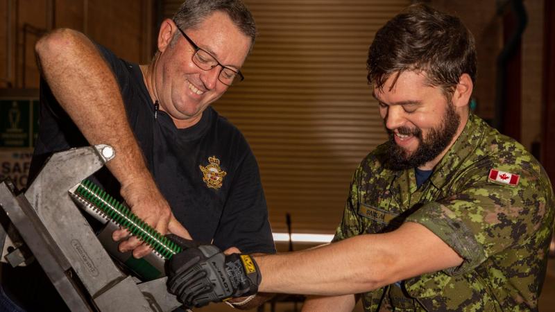 RAAF ground support equipment technician Corporal James Harding, left, and Royal Canadian Air Force aircraft arrestor systems technician Corporal Evan Barbeau maintain a BAK arrestor arm. Photo: Leading Aircraftwoman Annika Smit