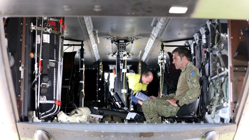 Major Waldo Britz prepares test equipment on a 5th Aviation Regiment MRH90 Taipan helicopter at RAAF Base Townsville. Photo: Corporal Lisa Sherman