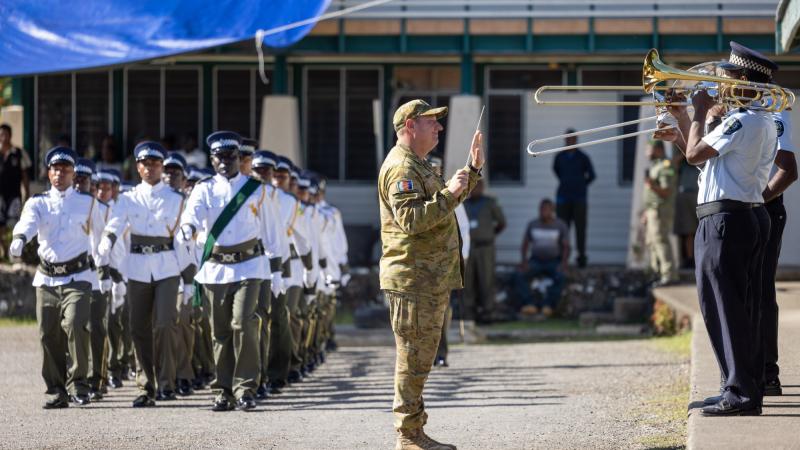 WO1 Mick Beeton, from the 1st Field Regiment Band, leads the Solomon Islands Police Force band during a march-out parade for new recruits in Honiara. Photo: Corporal Jonathan Goedhart