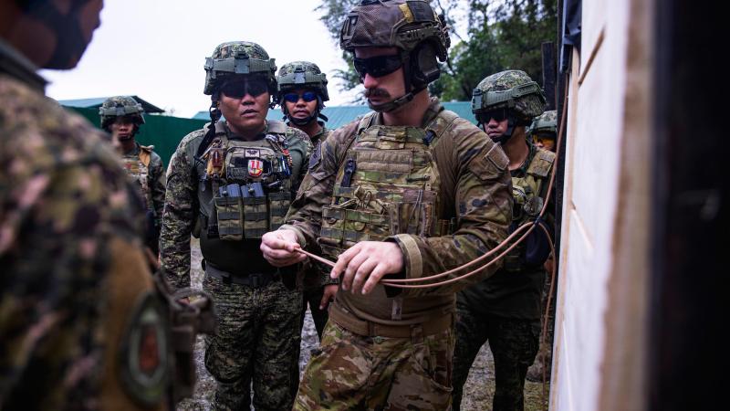 Australian Army soldier Corporal Connor McLeod explains to members of the Armed Forces of the Philippines how to attach a detonator to a breaching charge in the Philippines. Photos: Corporal Julia Whitwell