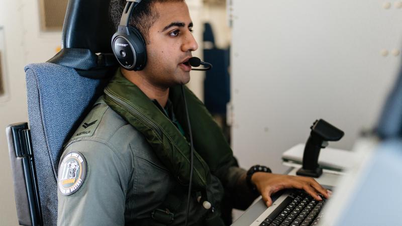 Royal Australian Air Force Corporal Mathan Sundaramoorthy works at his station on board a P-8A Poseidon aircraft during a maritime security mission while deployed on Operation Sea Guardian in Sicily. Photo: Corporal John Solomon