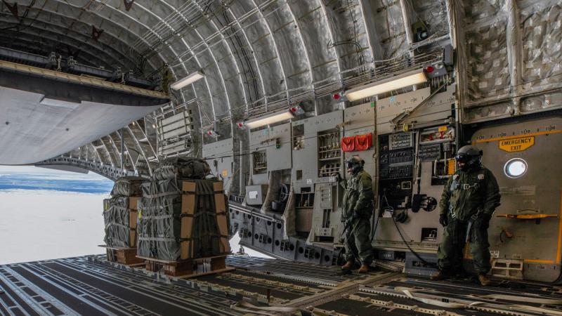 36 Squadron loadmasters Corporal Shaun Harding, left, and Flight Sergeant Rick Haslewood launch essential supplies from a C-17A Globemaster over Casey Station, Antarctica. Photo: Corporal Kylie Gibson