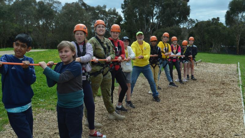 Lieutenant Amber Duncan from the 3rd Health Battalion jumps in to help with the giant swing during the unit's community engagement day with Camp Quality in Camp Mylor, South Australia. 