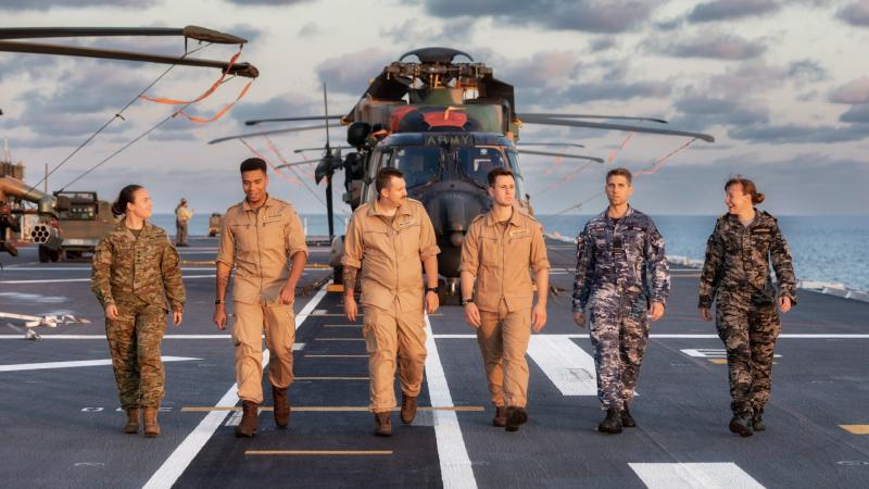 Australian Defence Force and German Navy members walk along the flight deck of HMAS Adelaide during Indo-Pacific Endeavour 2022. Photo: Leading Seaman Sittichai Sakonpoonpol