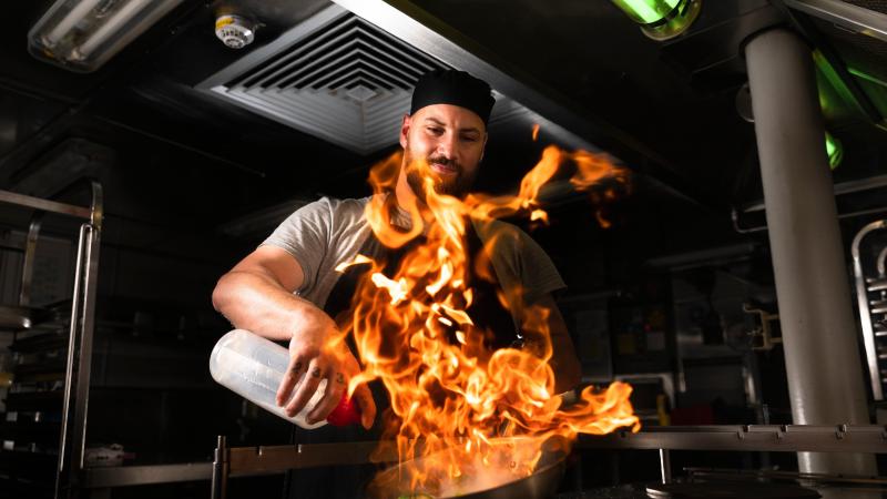 Maritime Logistics Chef Able Seaman Daniel Crowther prepares food in the galley on board HMAS Hobart during a regional presence deployment. Photo: Leading Seaman Daniel Goodman