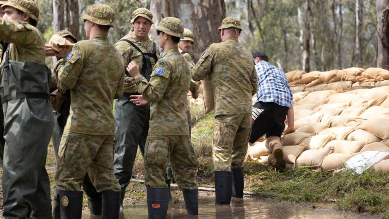 Private Jeremy Ryan, centre, of 8th/7th Royal Victorian Regiment, assists the community of Barmah, Victoria, with sandbagging as part of Operation Flood Assist 22-2. Photo: Corporal Jonathan Goedhart