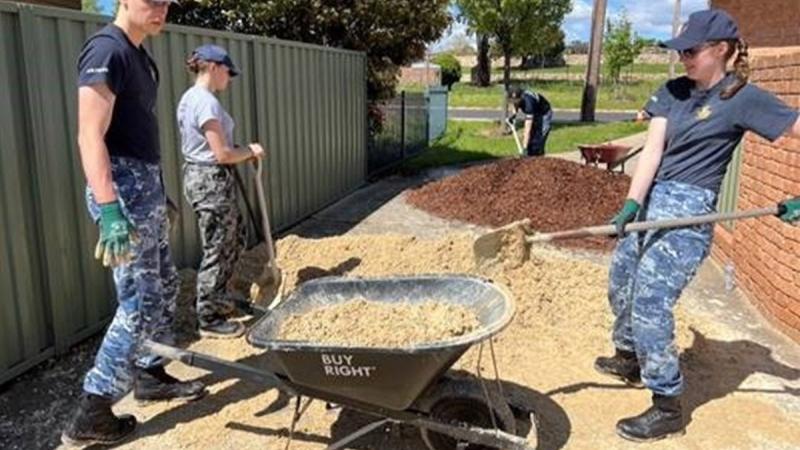 Australian Defence Force Academy trainee officers help garden and clean the backyard of a Canberra community member for the Canberra Youth Residential Service. Photo: Flight Lieutenant Nicole Beames
