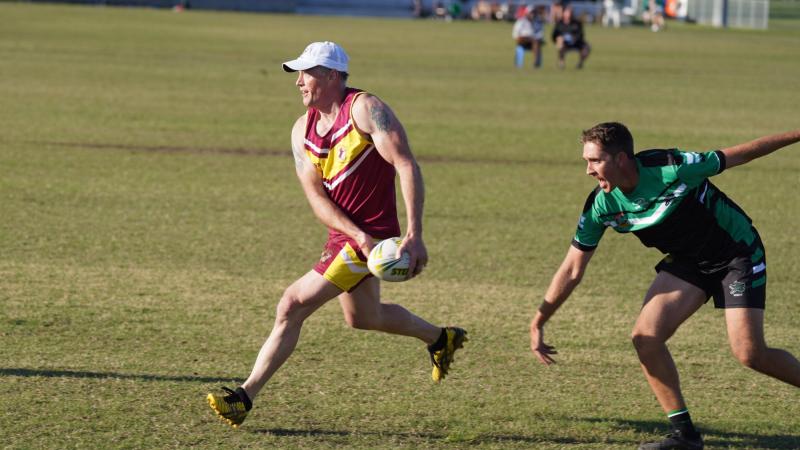 ACT/NSW Country’s Squadron Leader Danny Bretherton, left, works hard to evade the desperate defence of North Queensland’s Corporal Andrew Cooper. Photo: Supplied