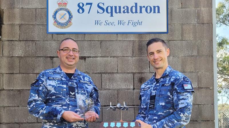 Corporal Kristopher Henderson, left, is presented with the 2022 Max Cowin Award by Commanding Officer No. 87 Squadron Wing Commander Jarrod Foster at RAAF Base Williamtown. 