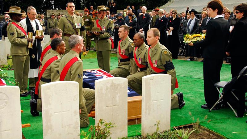 Australian Army personnel ready to take up the Australian flag from the coffin of Australian WWI soldiers being re-interred in Belgium. The soldiers were finally laid to rest after being thought missing for 90 years. Photo: Corporal Chris Moore