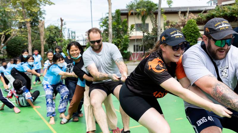 HMAS Arunta sailors take on the children from the Father Ray Foundation in Sattahip, Thailand, in a tug of war. Photos: Leading Seaman Susan Mossop