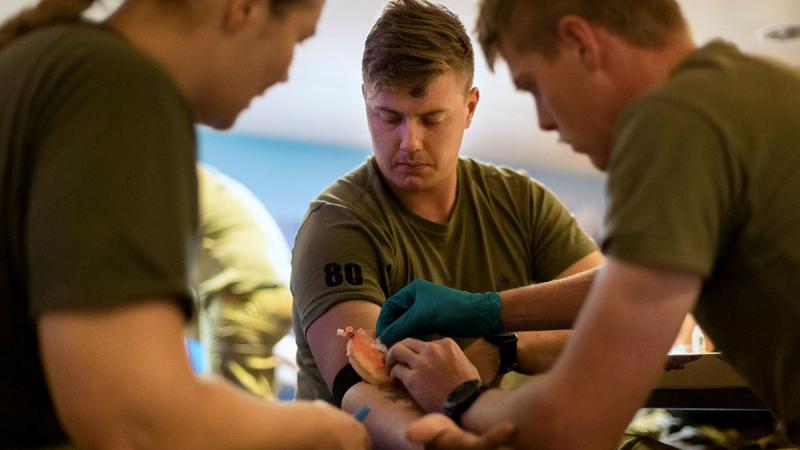 Private Samuel Sutcliffe, centre, from 1st Battalion, Royal Australian Regiment, volunteers as a patient during combat first aid training. Leading Seaman Sittichai Sakonpoonpol