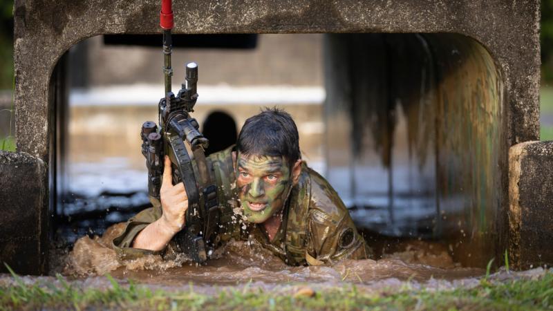 Major Jared Slansky of the 8th/9th Battalion, Royal Australian Regiment, emerges from the bear pit tunnel during Exercise True Grit at Tully training area, Queensland. Photos: Sergeant Matthew Bickerton