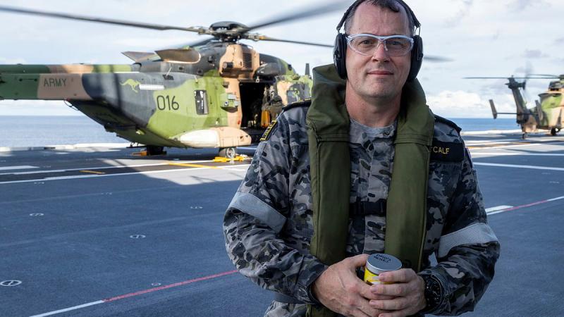Petty Officer Jean Metcalf on the flight deck of HMAS Adelaide before scattering his father's ashes from an MRH-90 Taipan. Photo: Leading Seaman Sittichai Sakonpoonpol