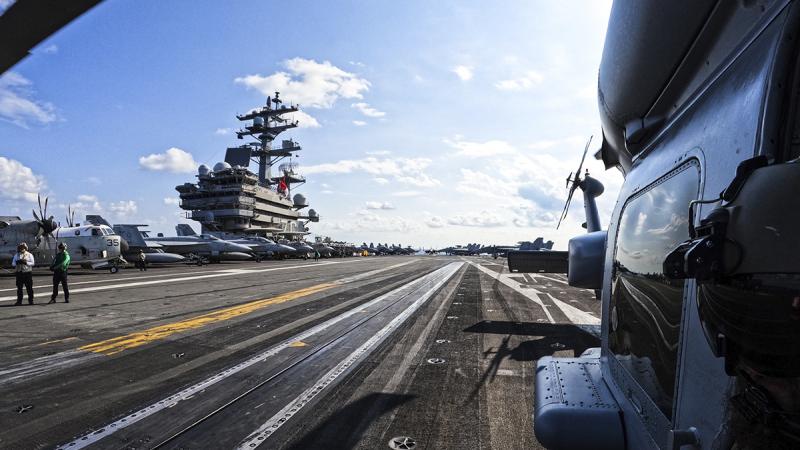 Leading Seaman Aircrewman Jake Williams looks out from HMAS Hobart's embarked MH-60R helicopter ‘Carnage’ during a cross-deck onto US Navy Aircraft Carrier, USS Ronald Reagan. Photo: Able Seaman Emily Johnson