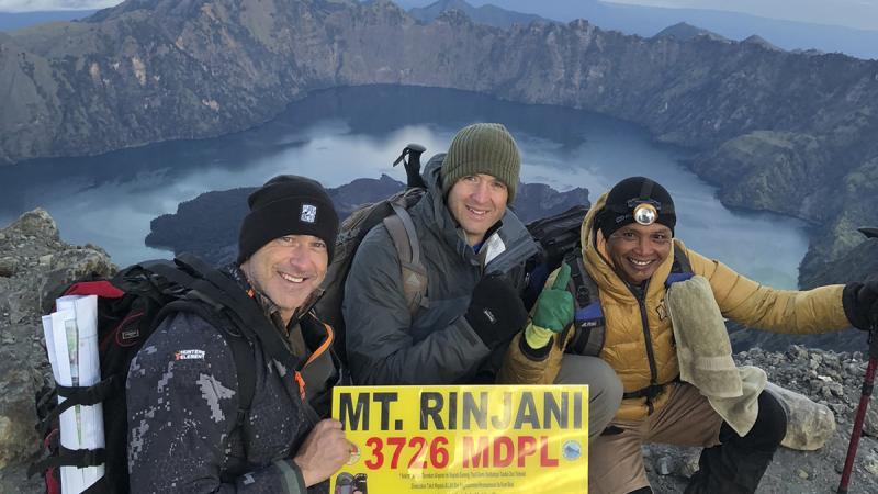 Squadron Leader Alex Smith, left, and fellow student, USAF Major Roy Stone, centre, reach the summit of Mt Rinjani at dawn with their guide. Squadron Leader Alex Smith