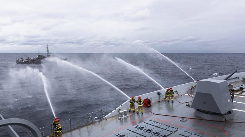 HMAS Hobart's ship's company render firefighting assistance to Japan Maritime Self-Defense Force minesweeping tender JS Bungo during a damage control exercise. Photo: Leading Seaman Daniel Goodman