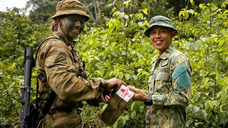 Private Kirsty Joyce from Rifle Company Butterworth Rotation 137 swaps patches with a Royal Brunei Land Force Medic from the 3rd Battalion. Photos: Bombardier Guy Sadler