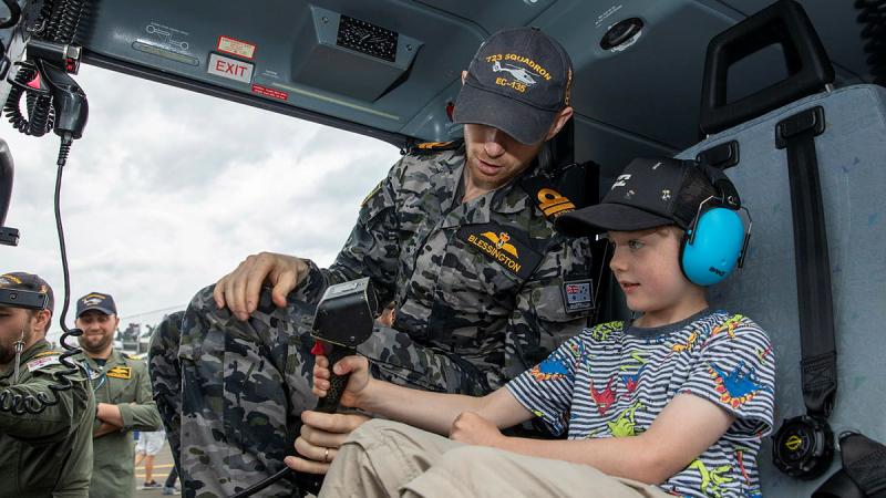Lieutenant Richard Blessington chats to Alex about the equipment inside an EC-135 helicopter at the 2022 Wings Over Illawarra Air Show. Photo: Leading Aircraftman Chris Tsakisiris