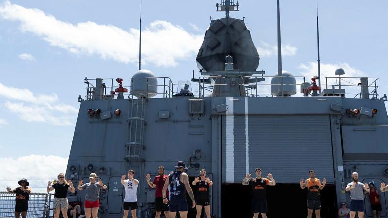 HMAS Arunta personnel conduct a warm up before the Teddy Sheean, VC, Commemorative Workout. Photo: Leading Seaman Susan Mossop