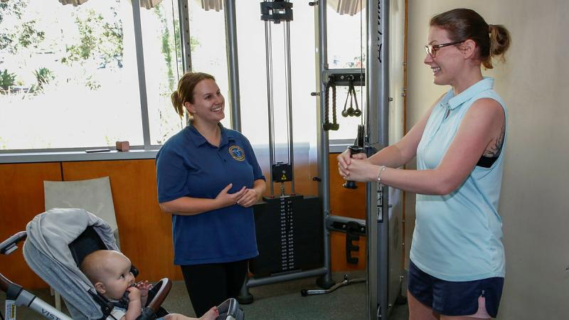Leading Aircraftwoman Anna-Jayne Forrest, right, with daughter Millie, attends 1 Expeditionary Health Squadron's strength and conditioning session at RAAF Base Amberley. Photo: Sergeant Peter Borys