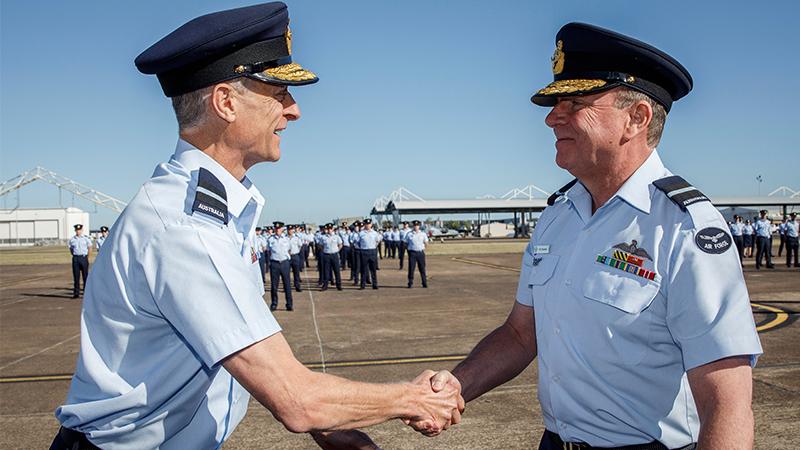 Outgoing Commander Air Combat Group, Air Commodore Tim Alsop (left) congratulates the incoming Commanding Officer, Air Commodore Pete Robinson, CSM on officially taking over command during the Hand Over - Take Over parade at RAAF Base Williamtown, New South Wales. Photos by CPL Craig Barrett