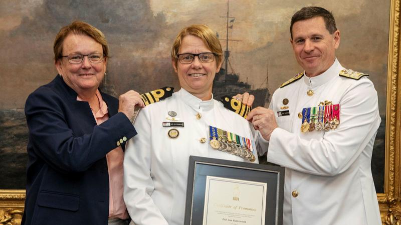Warrant Officer of the Navy Deb Butterworth, centre, receives her promotion to commander by the Chief of Navy Vice Admiral Mark Hammond, right, accompanied by her partner Tracy. Photo: Petty Officer Bradley Darvill