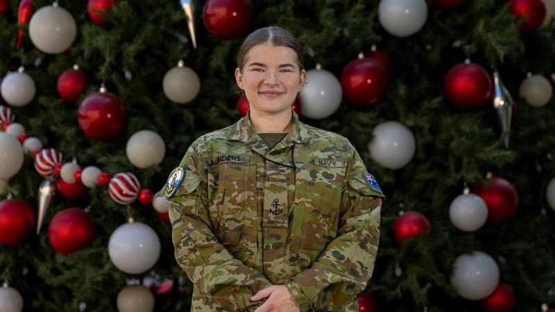 Leading Seaman Olivia Saunders stands in front of the US bases Christmas tree, Bahrain. Photo: Corporal Jacob Joseph