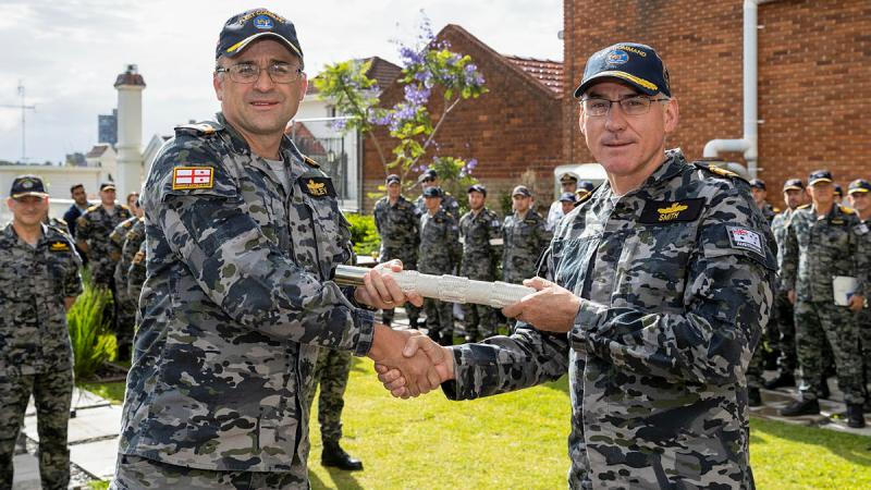 Rear Admiral Jonathan Earley hands over the 'weight of command' of His Majesty’s Australian Fleet to Rear Admiral Chris Smith during a ceremony at Fleet Headquarters, HMAS Kuttabul in Sydney. Photo: Leading Seaman Matthew Lyall